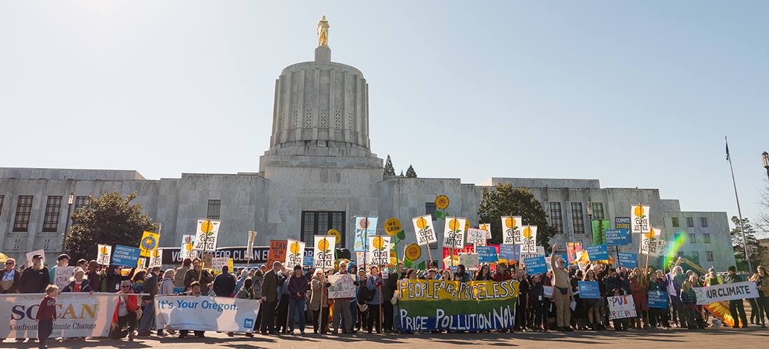 Large group of Environmental advocates holding signs out front of the state Capitol in Salem, Oregon.