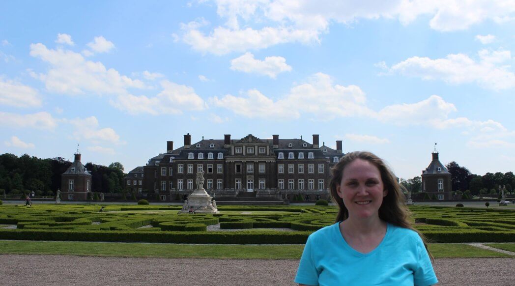 environmental health program director crystal weston standing in front of large mansion with hedge maze in front of it