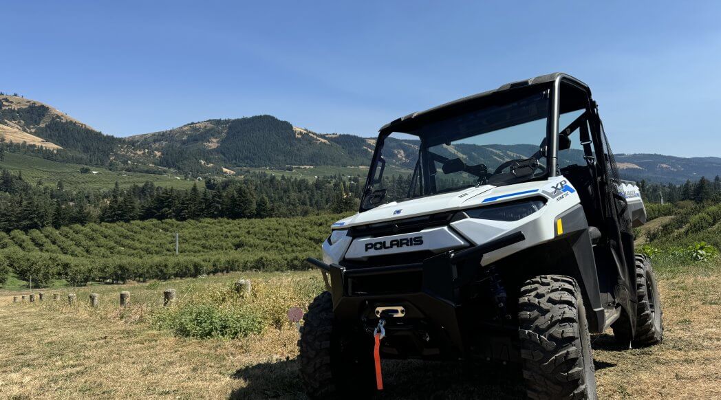 polaris electric UTV on a hood river farm in summer with blue skies and rolling hills in the background