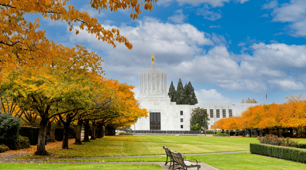 oregon state capitol building in salem in fall with orange leaves on the trees