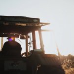 silhouette of person in tractor working a field